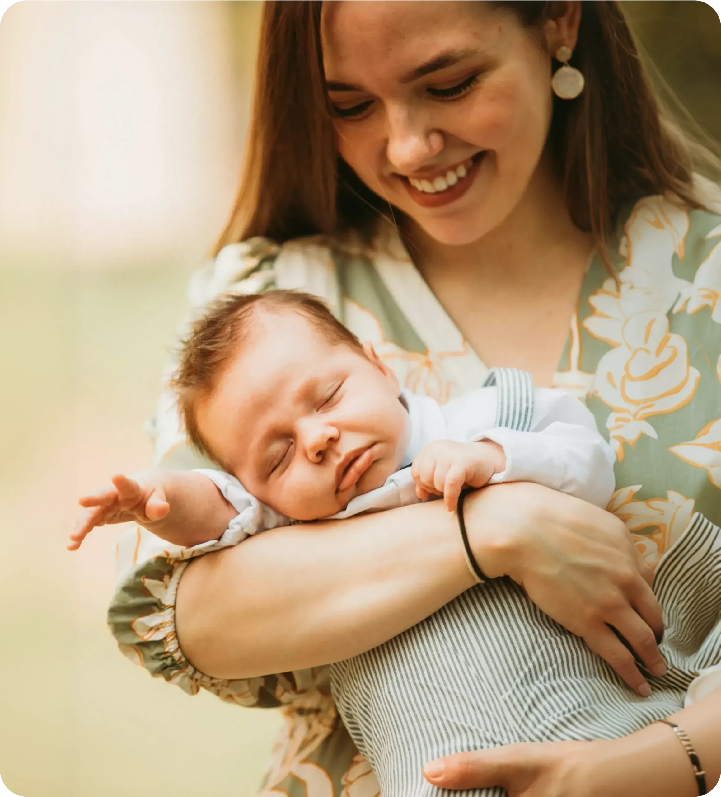 A happy mother holding her sleeping baby